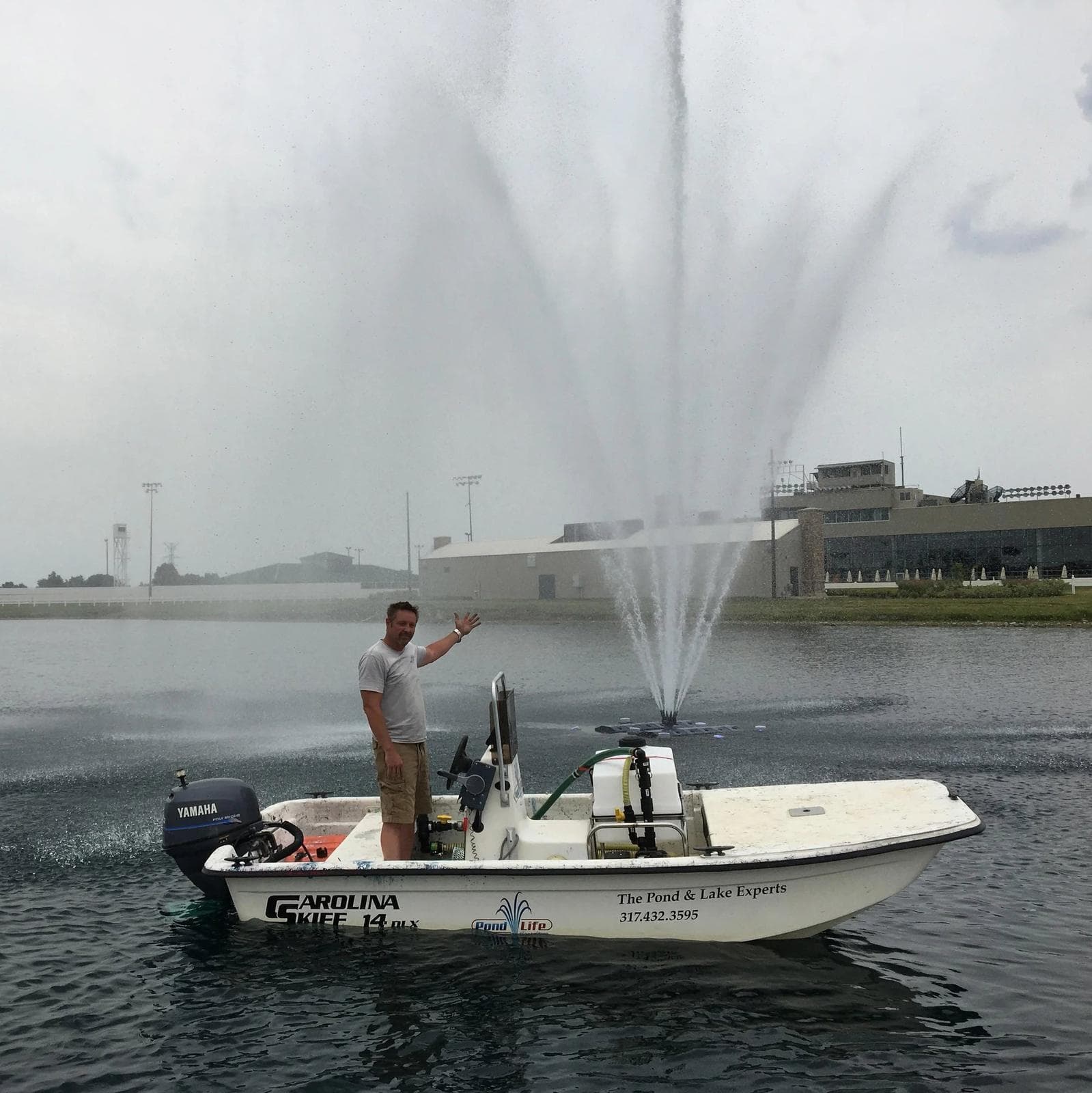 Blaine Hession on the Pond Life Consulting workboat beside a running fountain